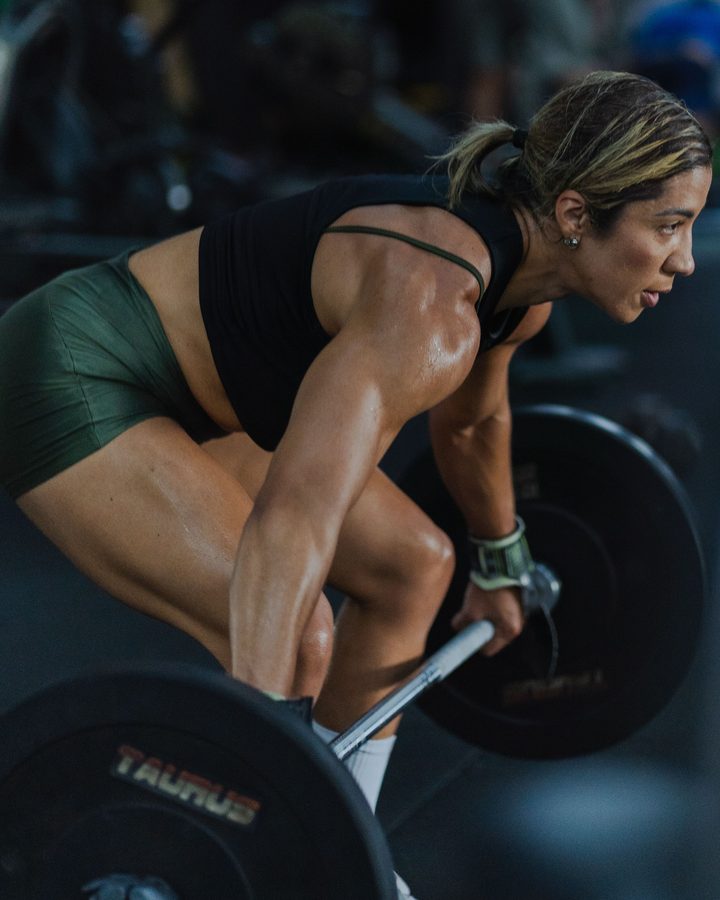 Athlete setting up for a deadlift in a dimly lit gym
